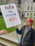 Protestor holding KKK sign at NRA convention 2019 Indianapolis, Indiana