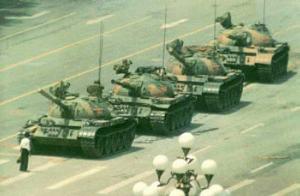 Picture of Tiananmen Square demonstrator defiantly standing before four tanks